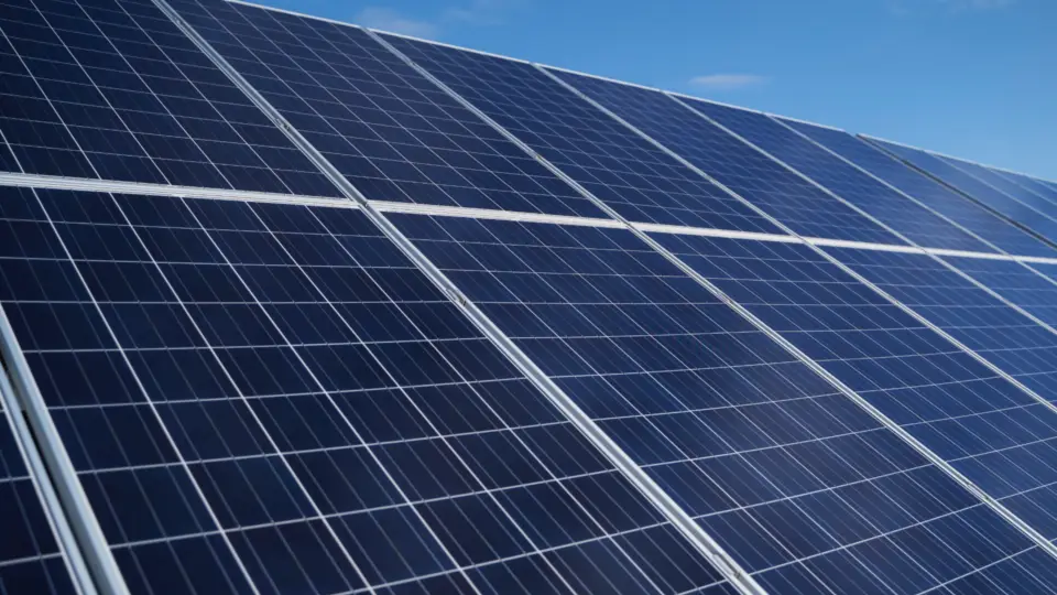 Zonnepanelen op een plat dak met zilveren CoolRoof Reflect dakcoating voor verbeterd rendement
